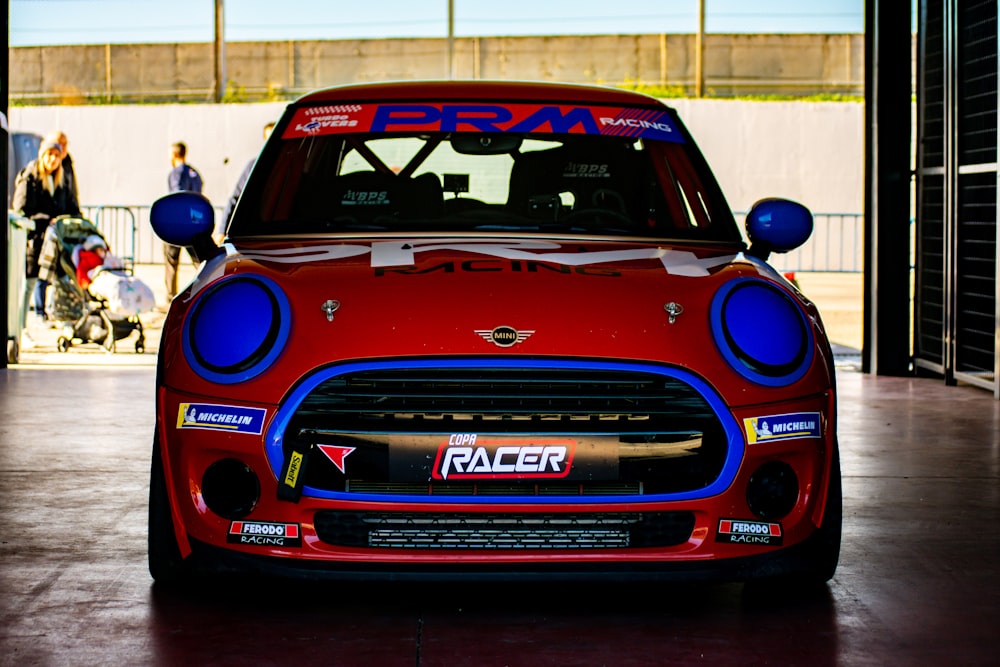 a red and blue mini car parked in a garage