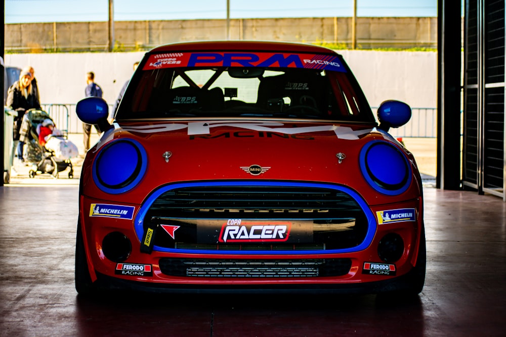 Une mini voiture rouge et bleue garée dans un garage