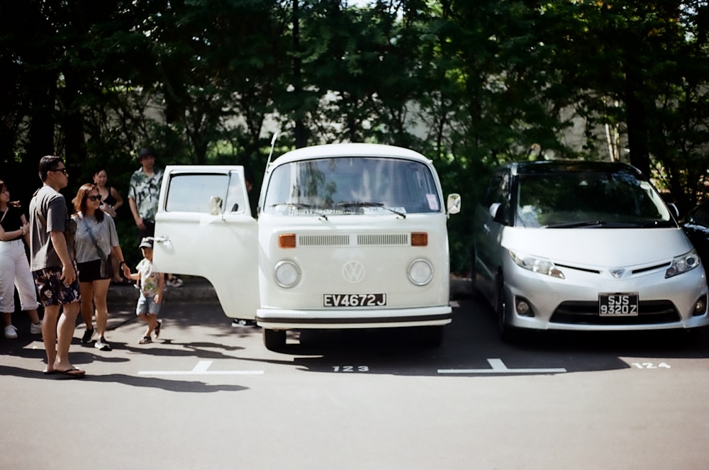 a group of people standing next to a white van