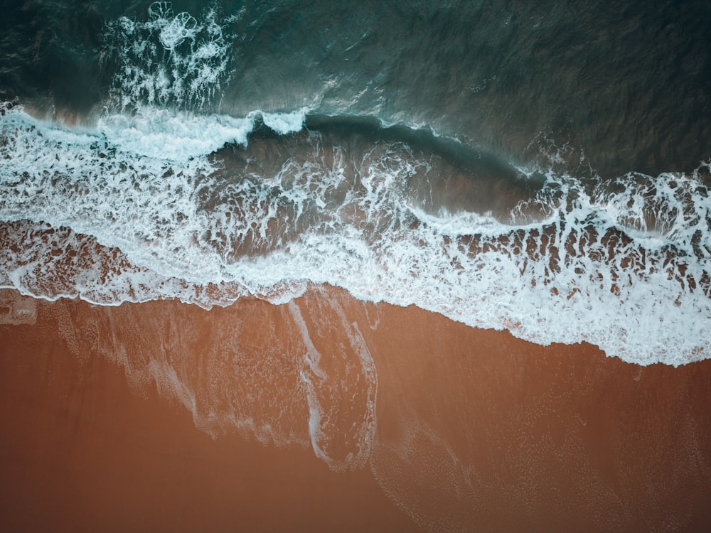 an aerial view of a beach with brown sand