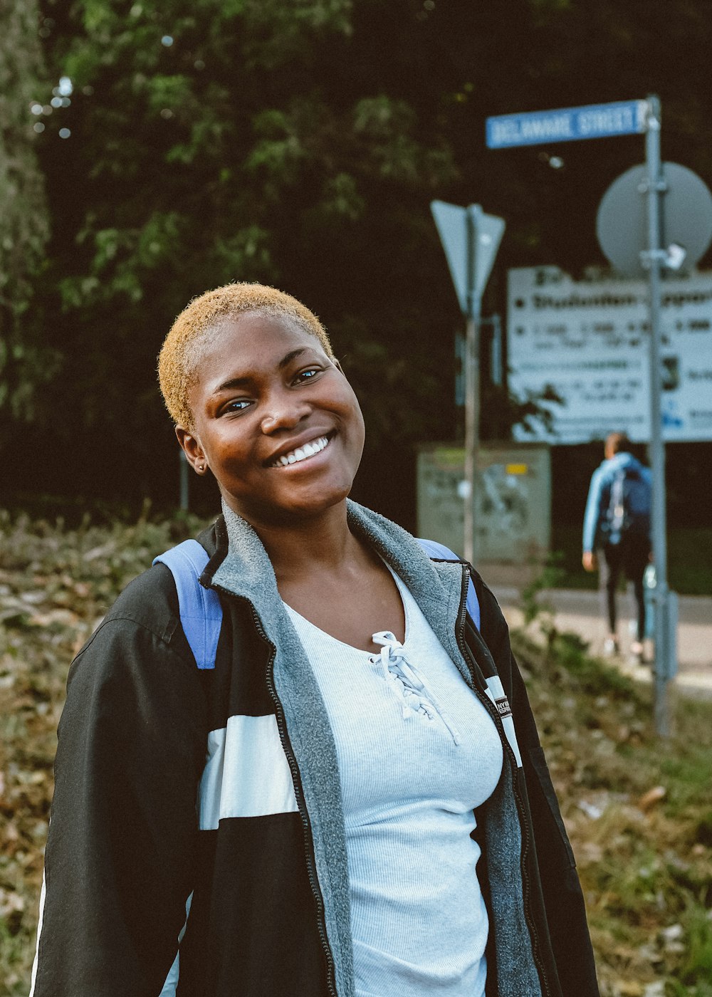 a woman standing in front of a street sign