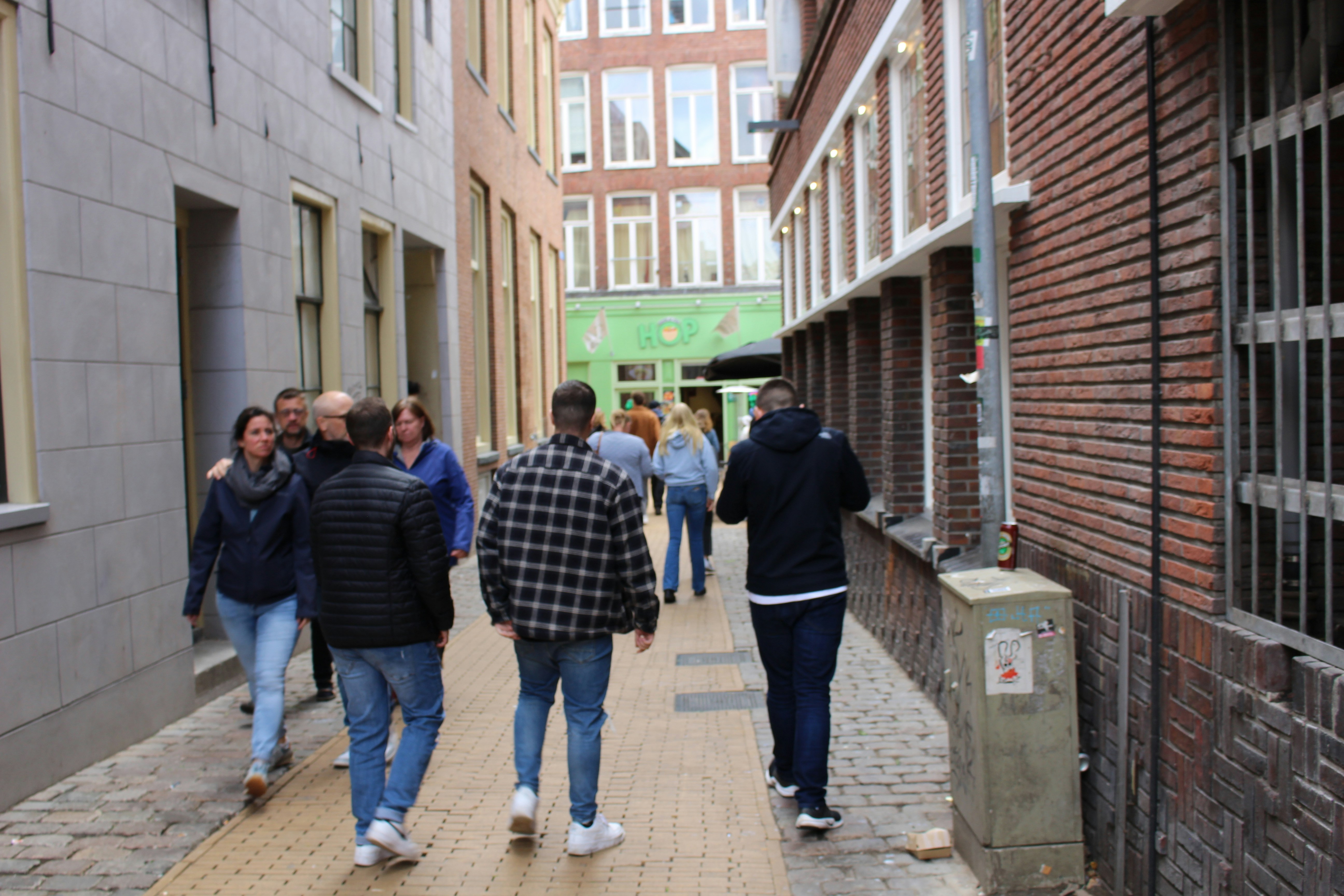 a group of people walking down a street next to tall buildings