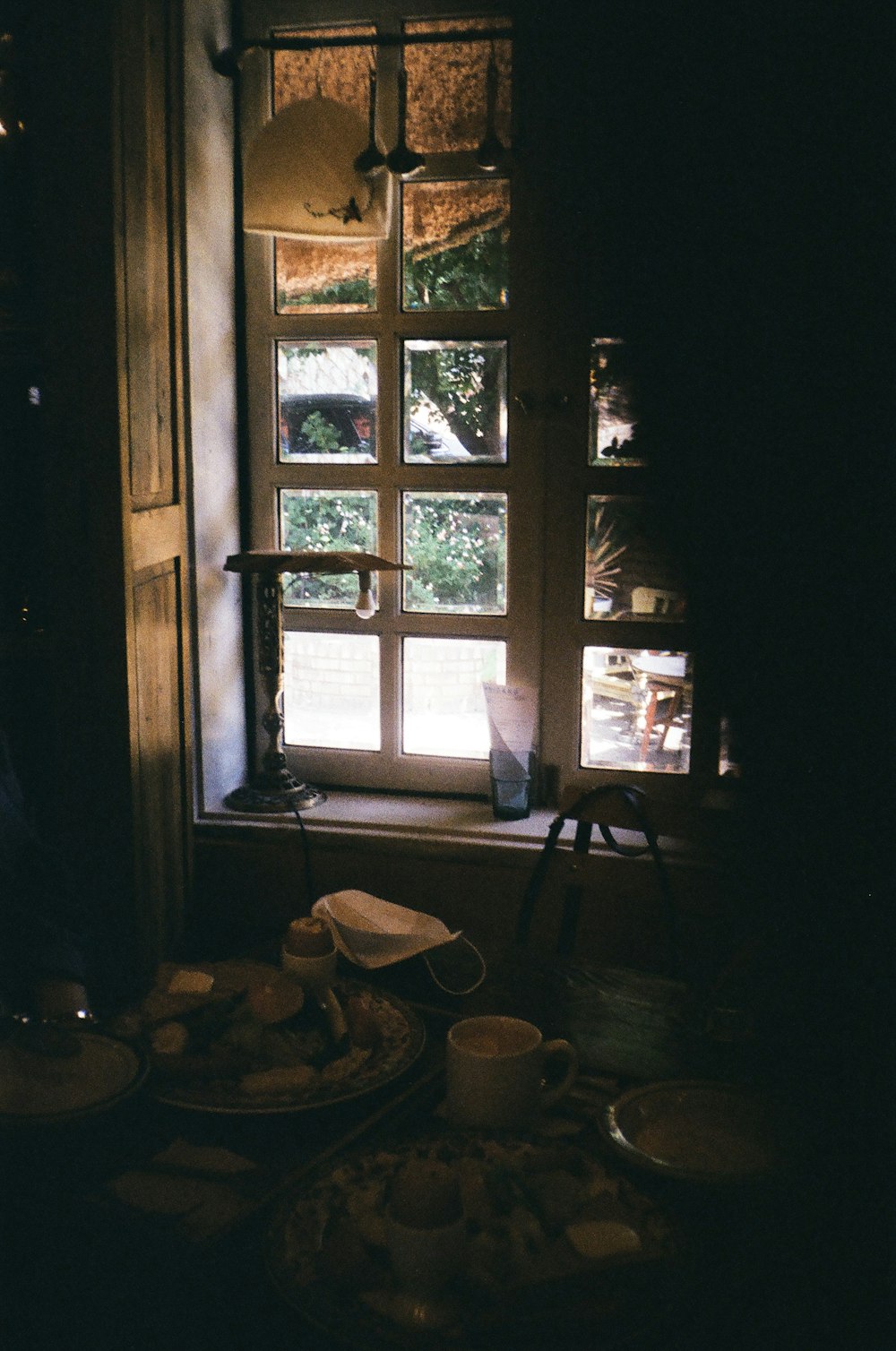 a table topped with plates of food next to a window
