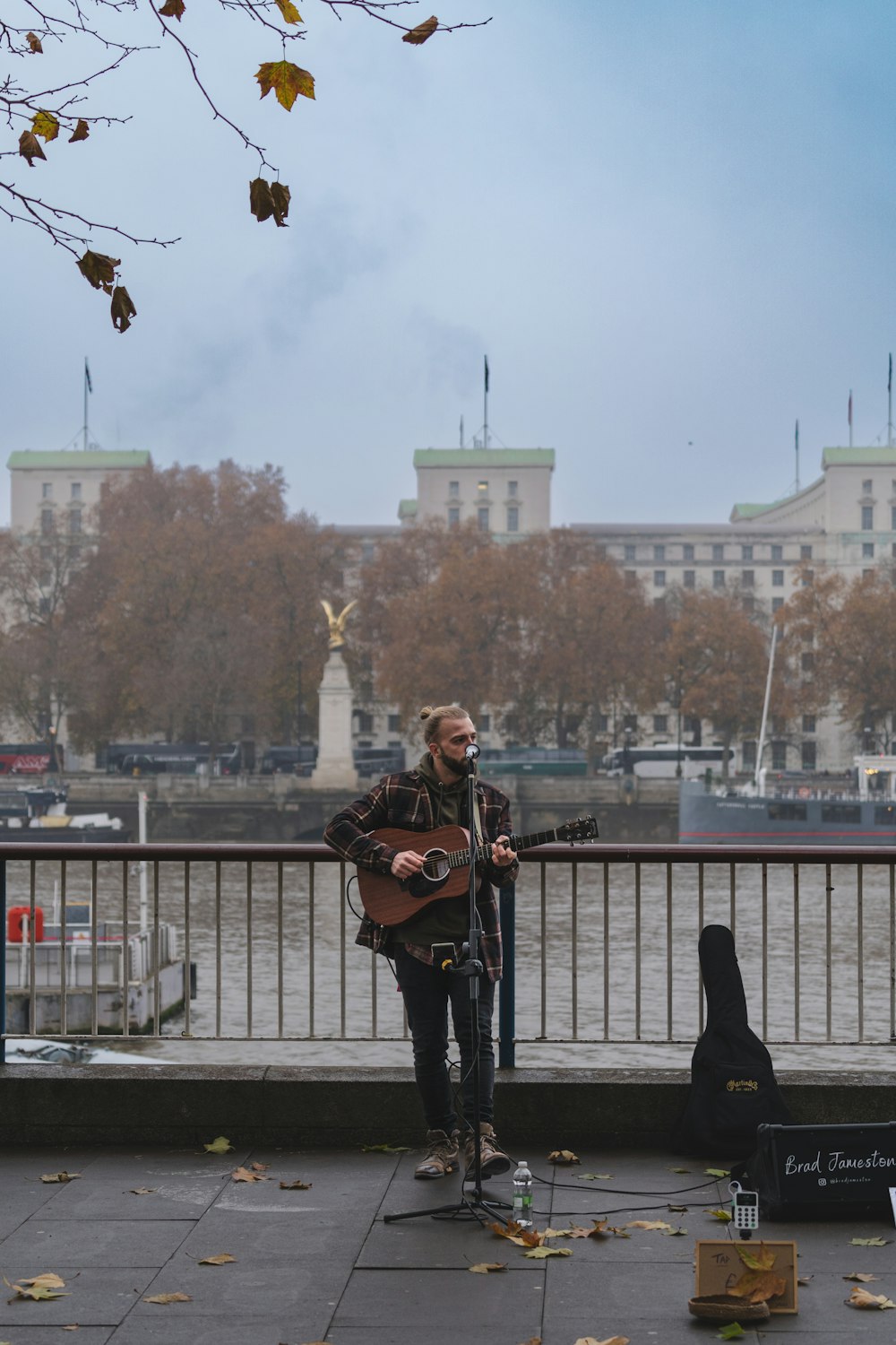 Un uomo che suona una chitarra su un ponte