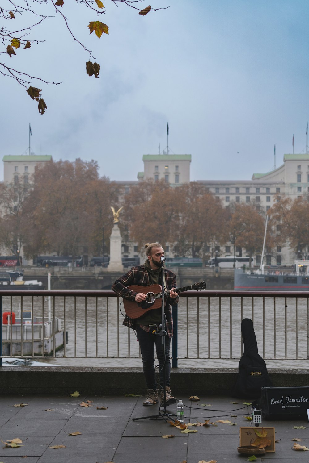 a man playing a guitar on a bridge