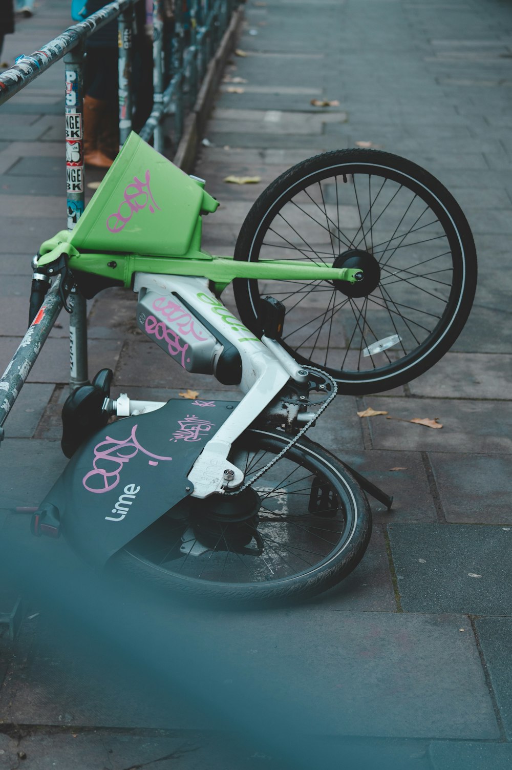 a bicycle with a green seat on a sidewalk