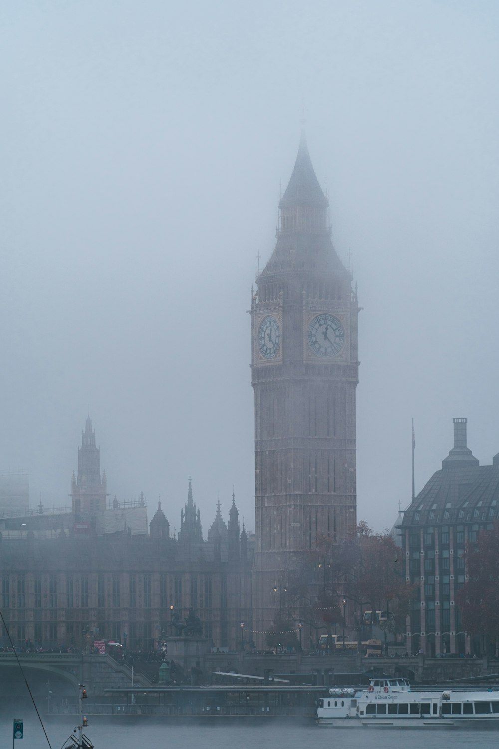 Una gran torre del reloj que se eleva sobre una ciudad en un día de niebla