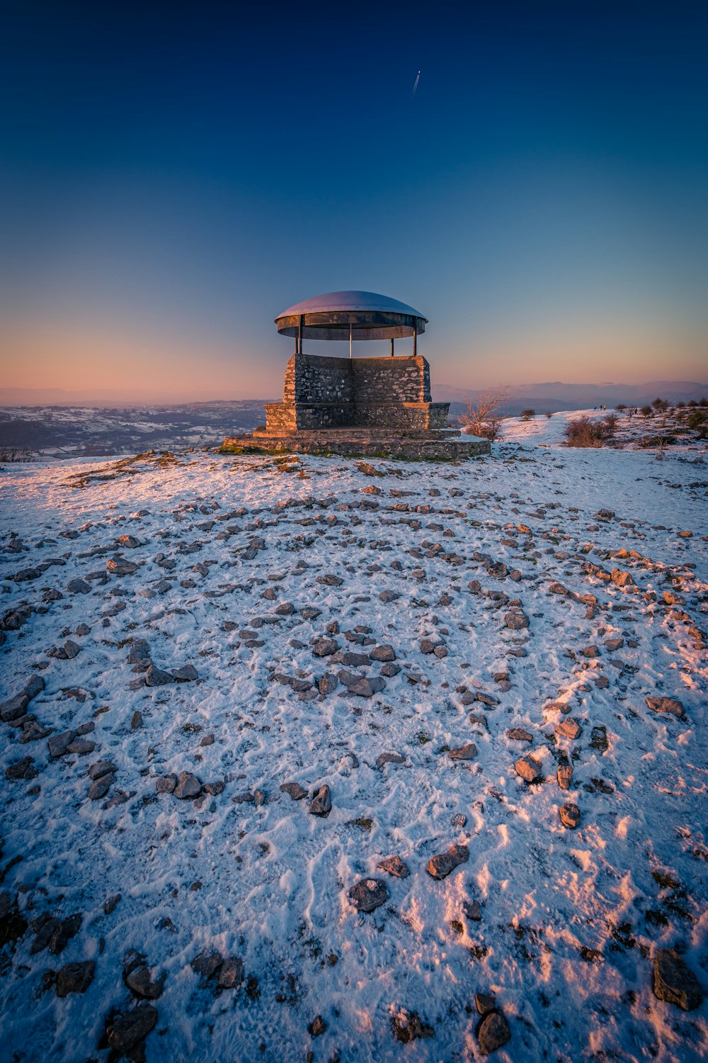 a gazebo in the middle of a snowy field