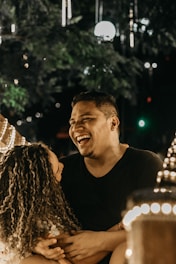 A joyful couple watching a romantic video together in a cozy setting.