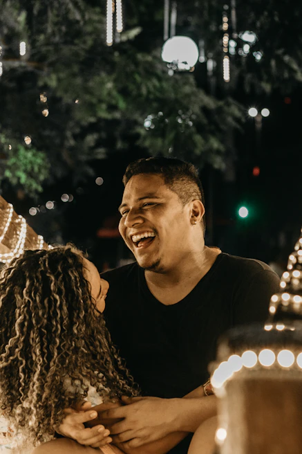 Couple sharing a romantic sunset by a cozy cabin decorated with lights