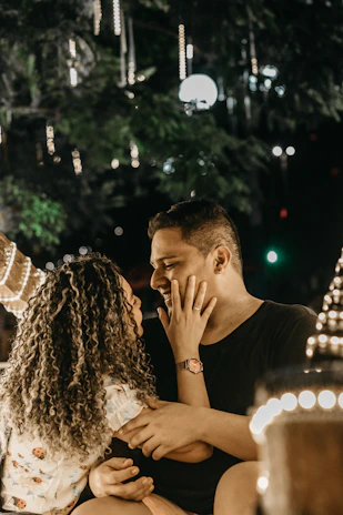 A couple enjoying a quiet, intimate outdoor date surrounded by soft evening lights.