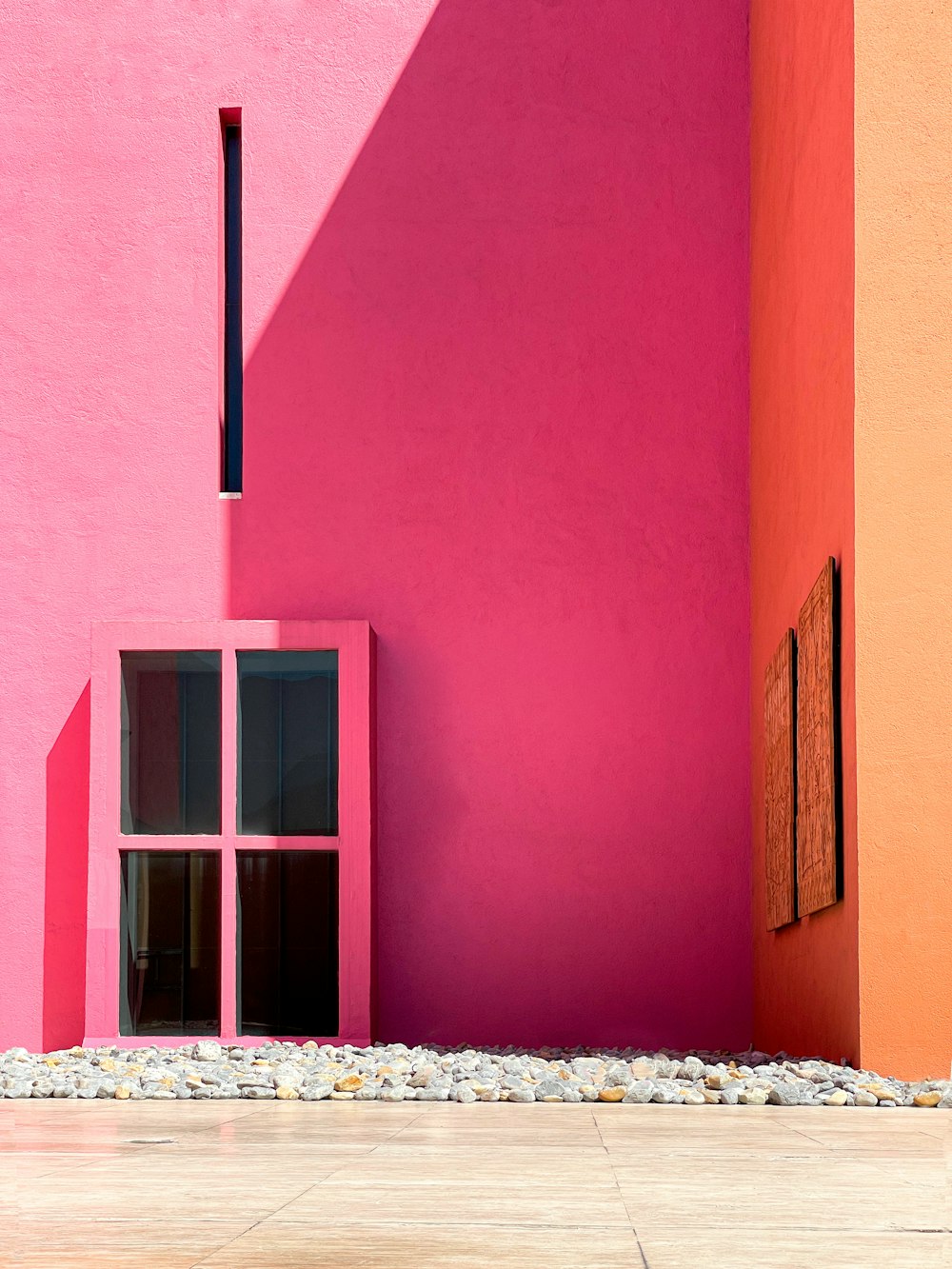 a pink and orange building with a window