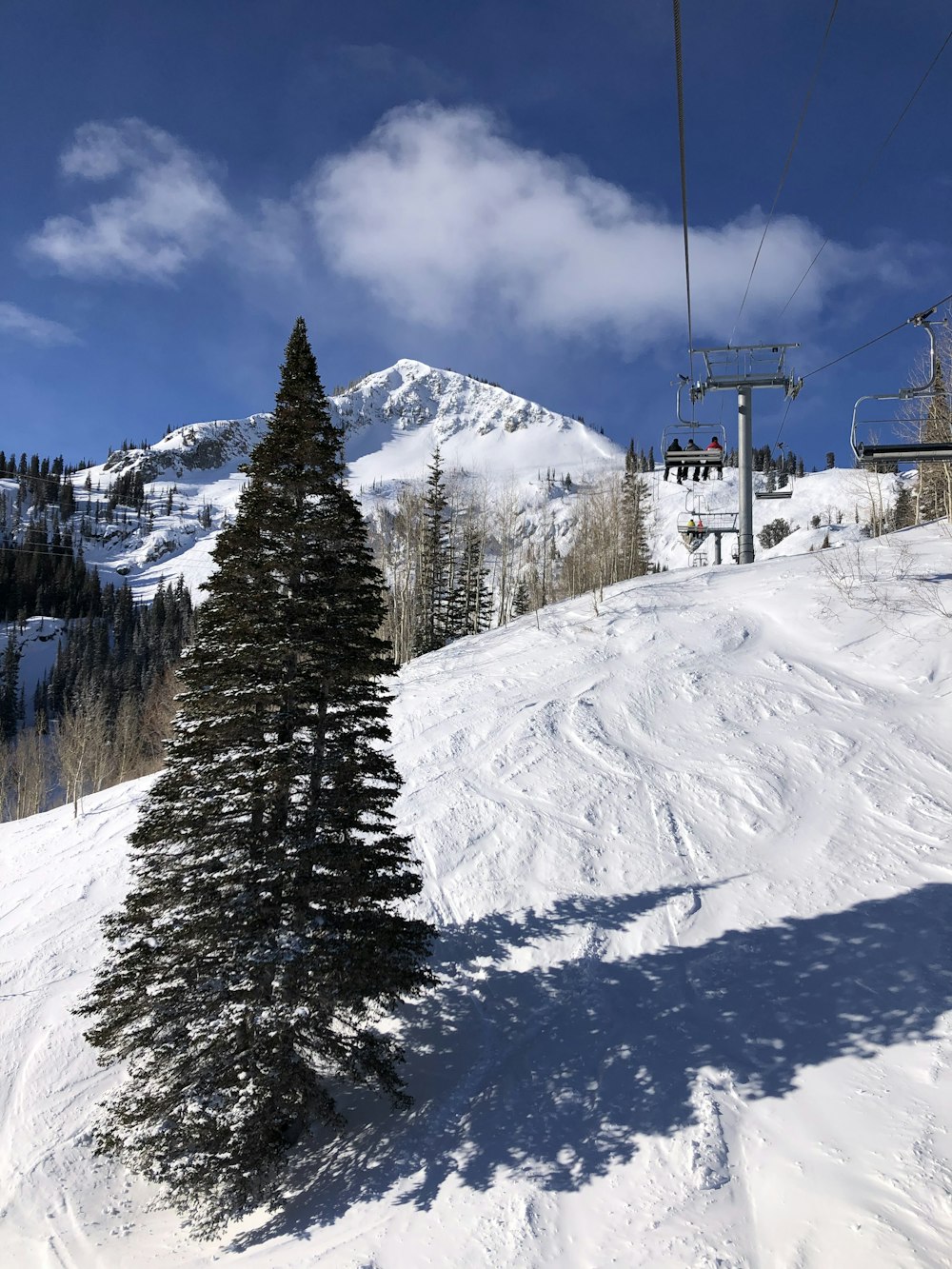 a snow covered ski slope with a chair lift in the background