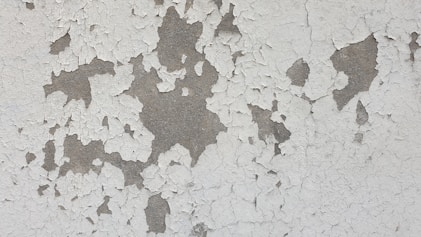 Close-up photo showing peeling lead paint on an old wall.