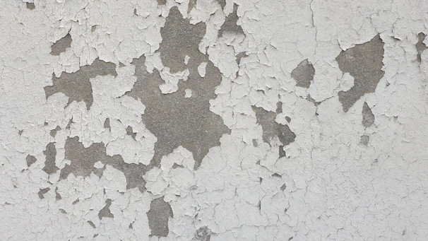 Close-up of peeling paint on an old building facade showing wear and tear.