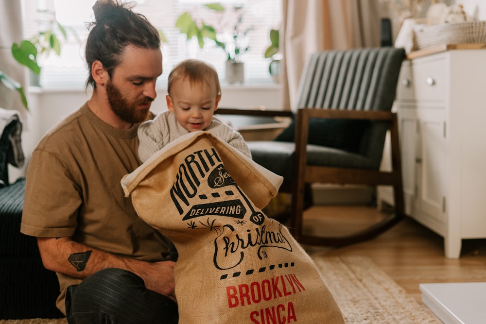 a man holding a baby in a bag