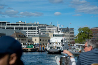 A panoramic view of a newly constructed ferry docked at a bustling harbor under clear skies.