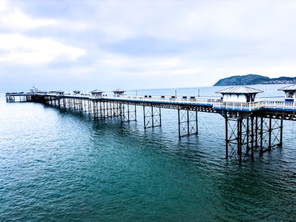 a pier on a body of water under a cloudy sky
