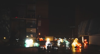 Close-up of colorful K-pop photo cards and lightsticks glowing softly in a cozy room.