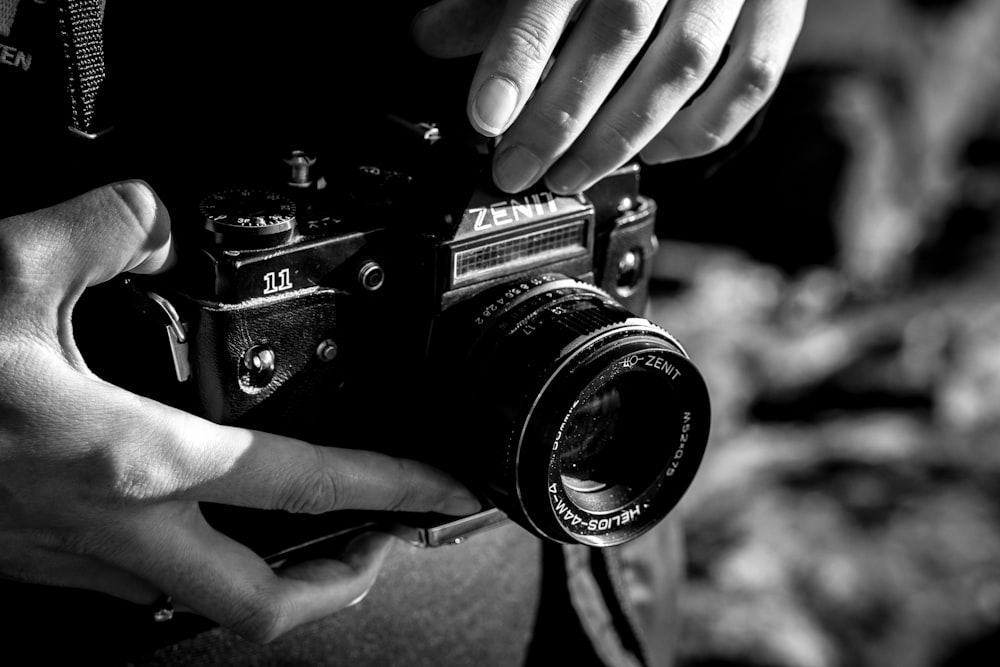 a black and white photo of a person holding a camera