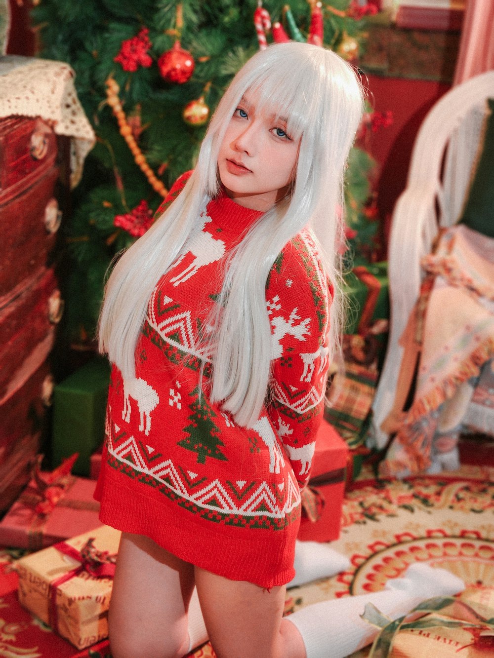 a woman with long white hair wearing a red sweater