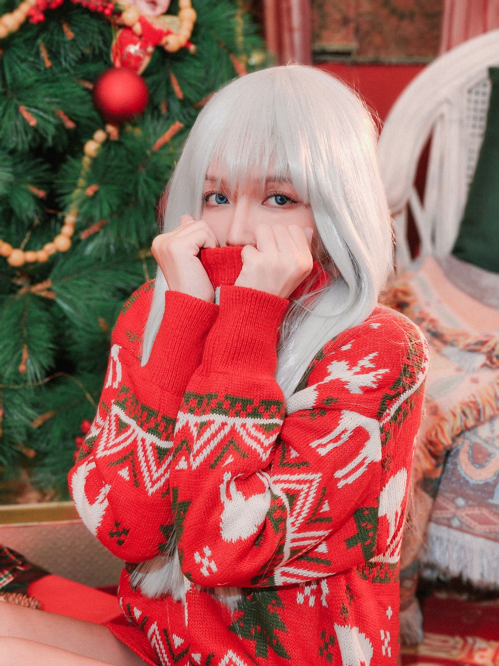 a woman with white hair wearing a red christmas sweater