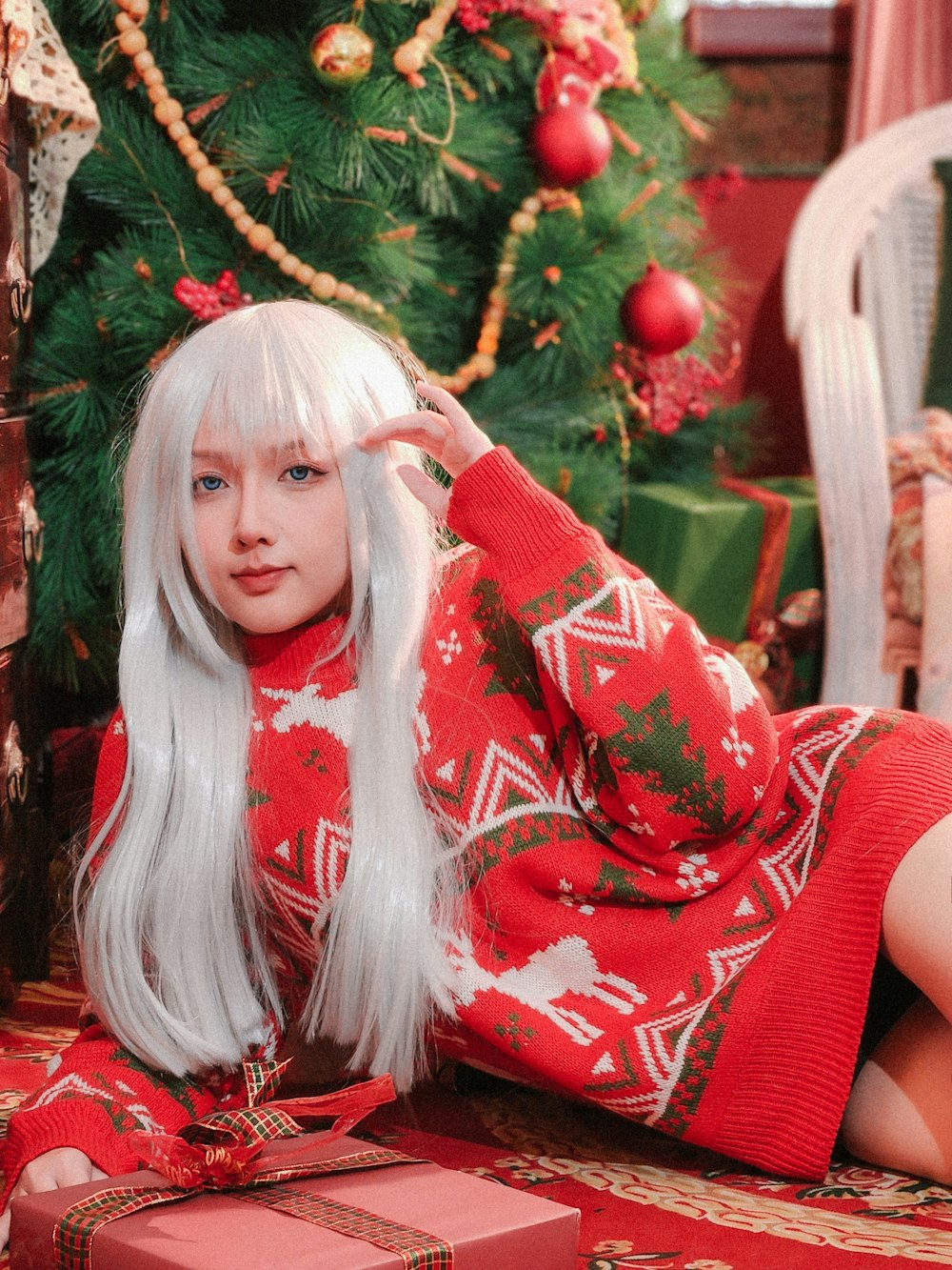 molino Paisaje Soviético Foto Una mujer con un suéter navideño rojo y blanco sentada junto a un  árbol de navidad – Imagen Ciudad de ho chi minh gratis en Unsplash