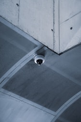 Security camera mounted on a ceiling corner overlooking a business entrance.