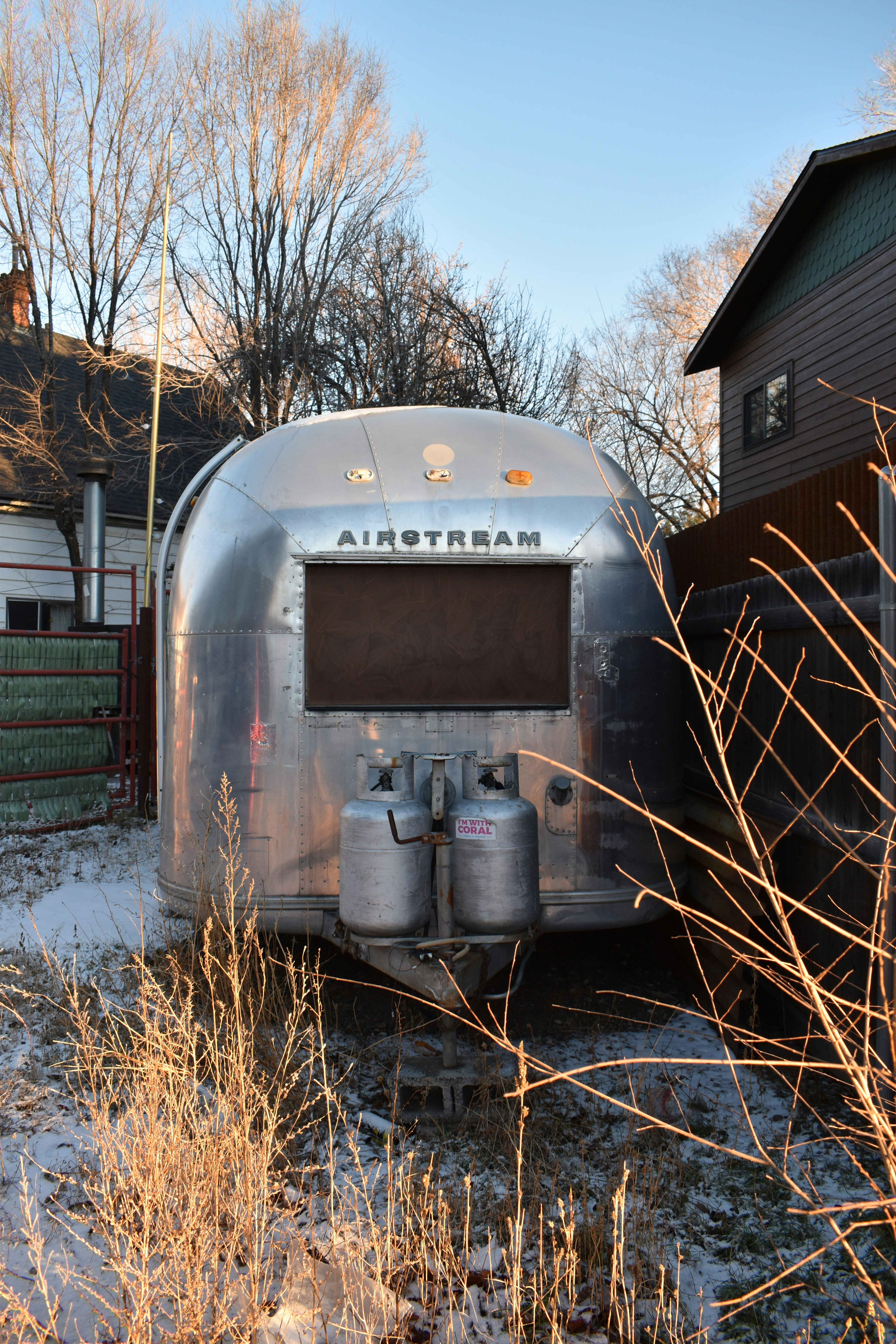 une remorque argentée garée devant une maison
