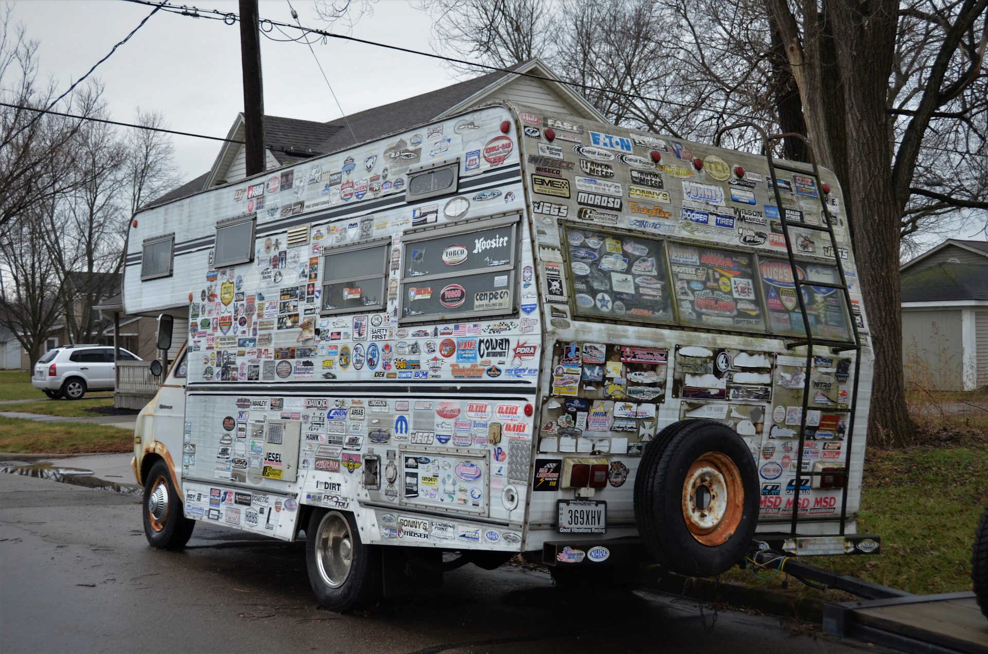 a van covered in stickers parked on the side of the road