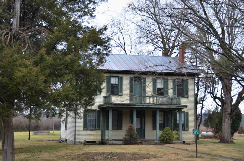 Historic farmhouse with a front porch and a metal roof