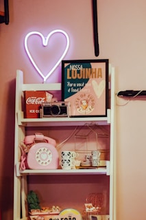 a shelf with a phone and a neon sign