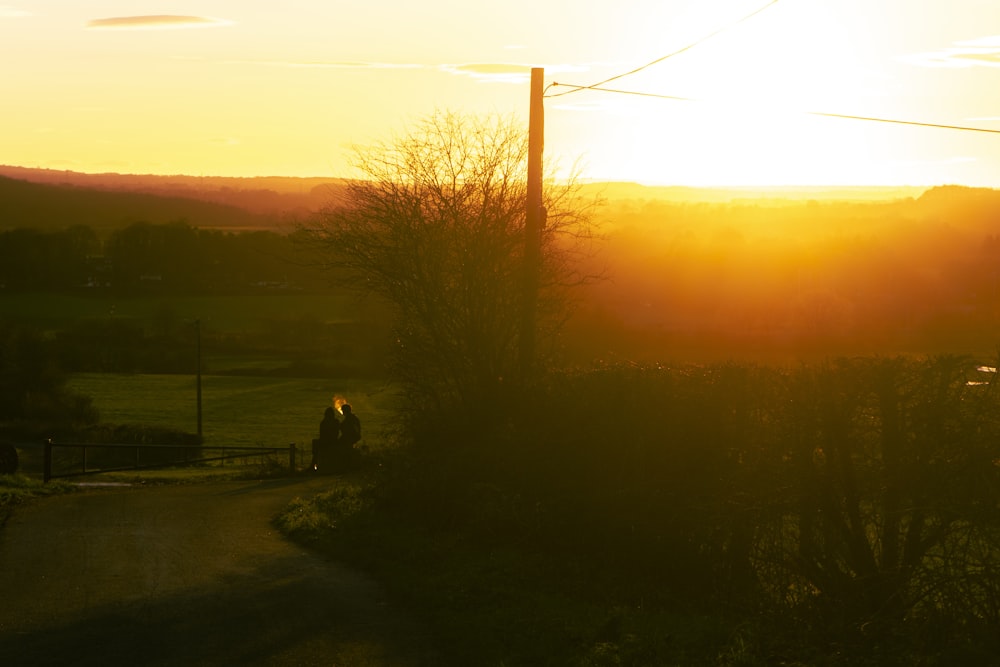 the sun is setting over a rural area