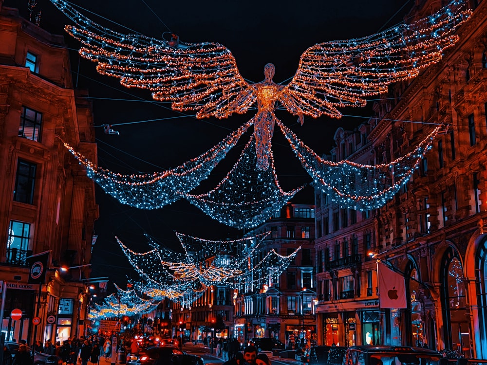 an angel statue is lit up on a city street