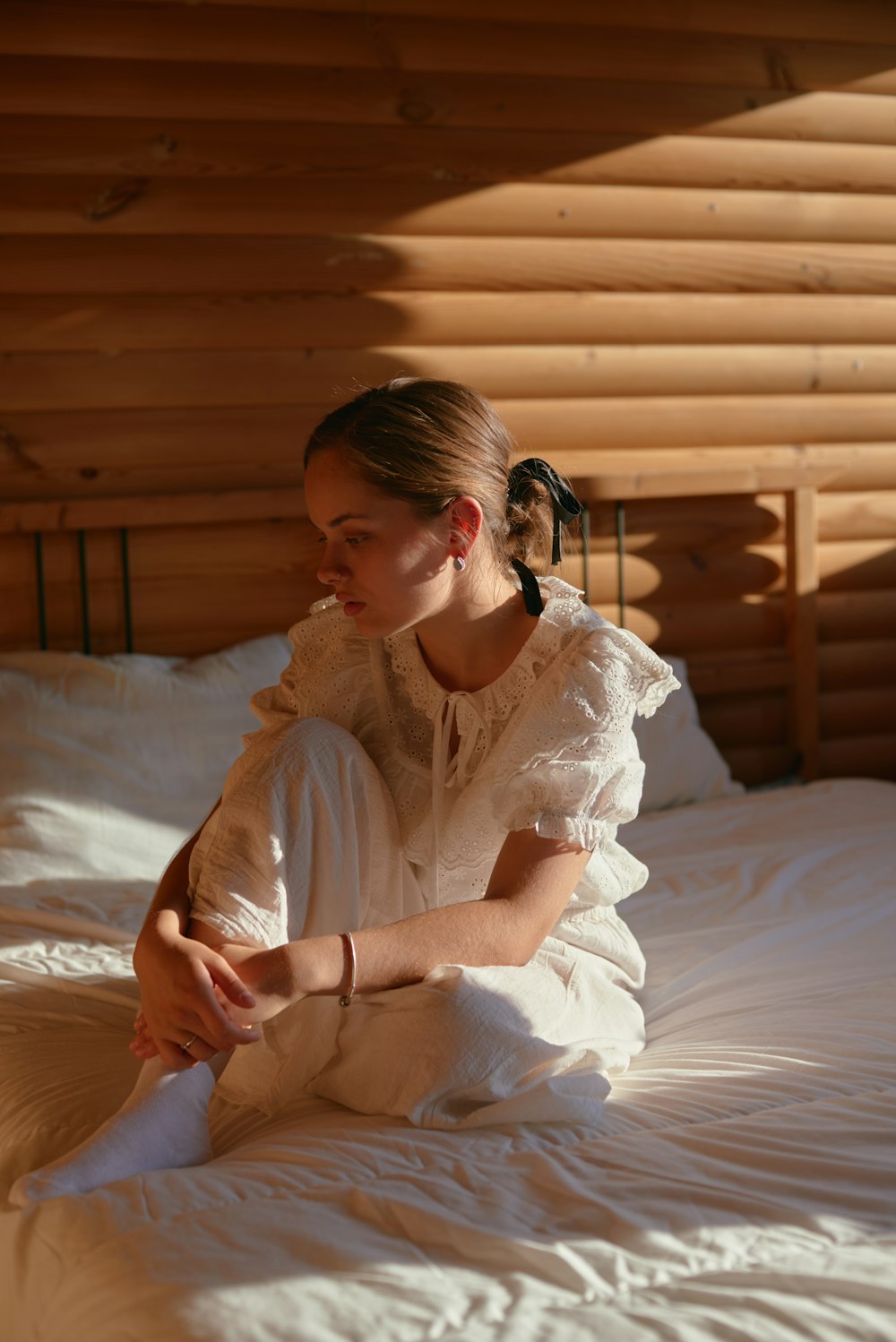 a woman sitting on a bed in a room