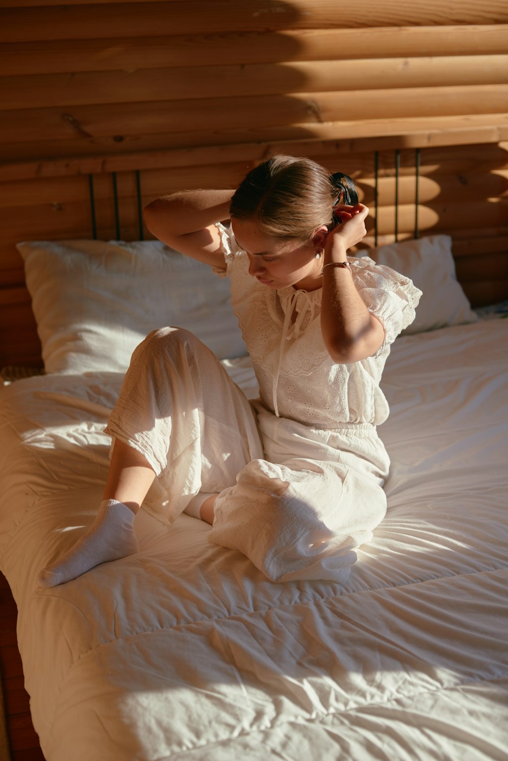 a woman sitting on a bed in a room