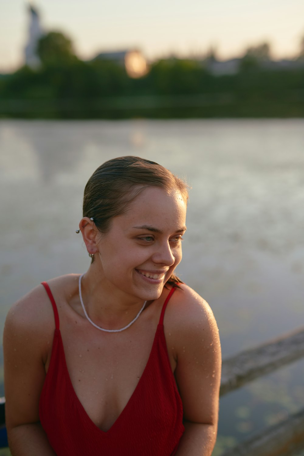 a woman in a red dress sitting next to a body of water