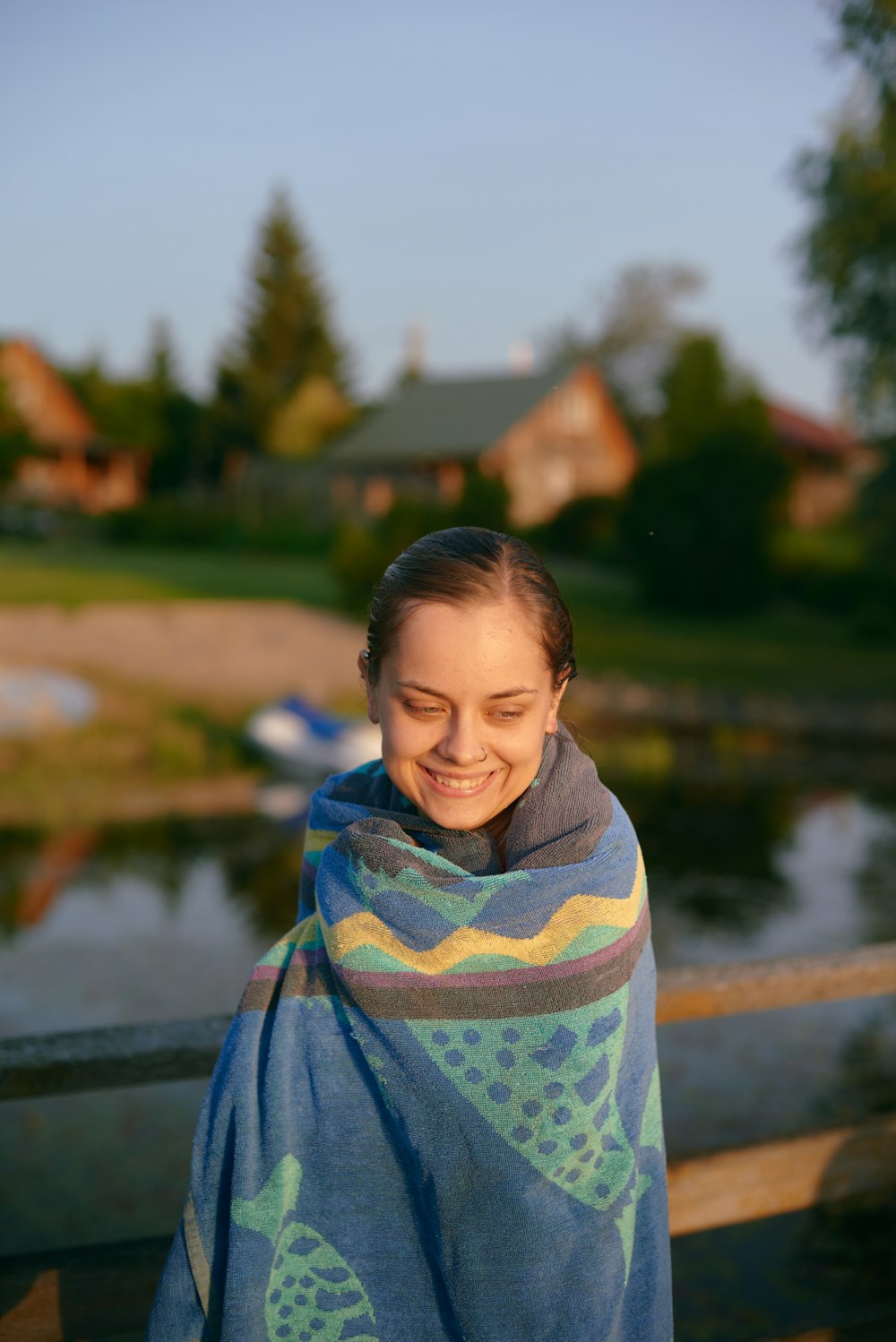 a woman wrapped in a blanket smiles at the camera