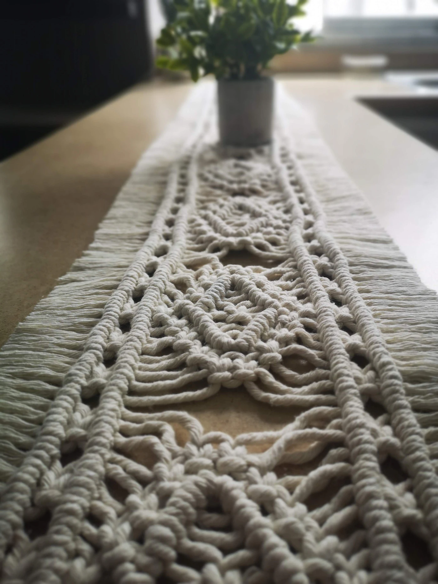 DIY table runners for boho weddings — A macramé table runner adds texture to a long reception table.