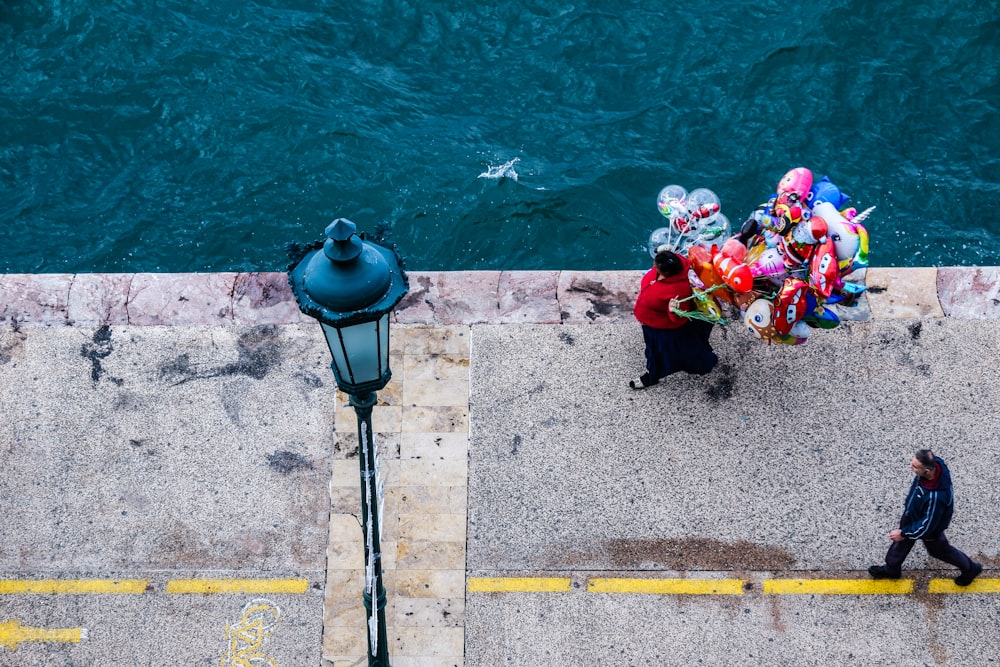 a person walking down a sidewalk next to a body of water