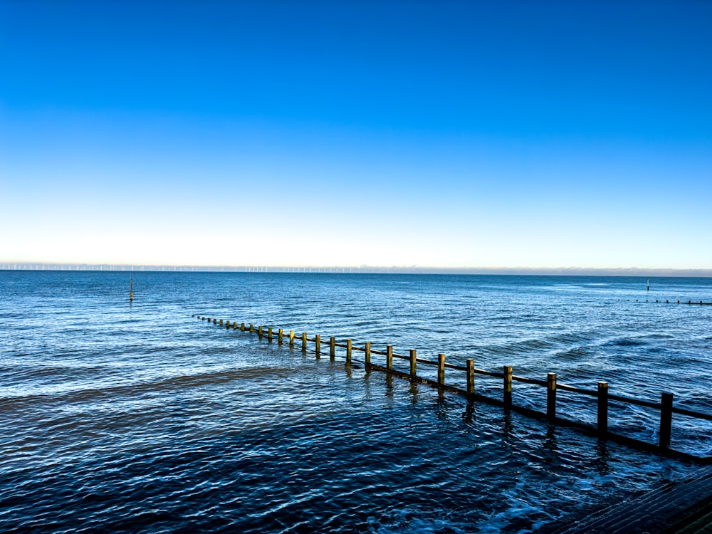 a long wooden pier stretching out into the ocean