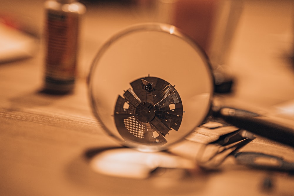 a magnifying glass sitting on top of a wooden table