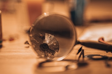 a magnifying glass sitting on top of a wooden table