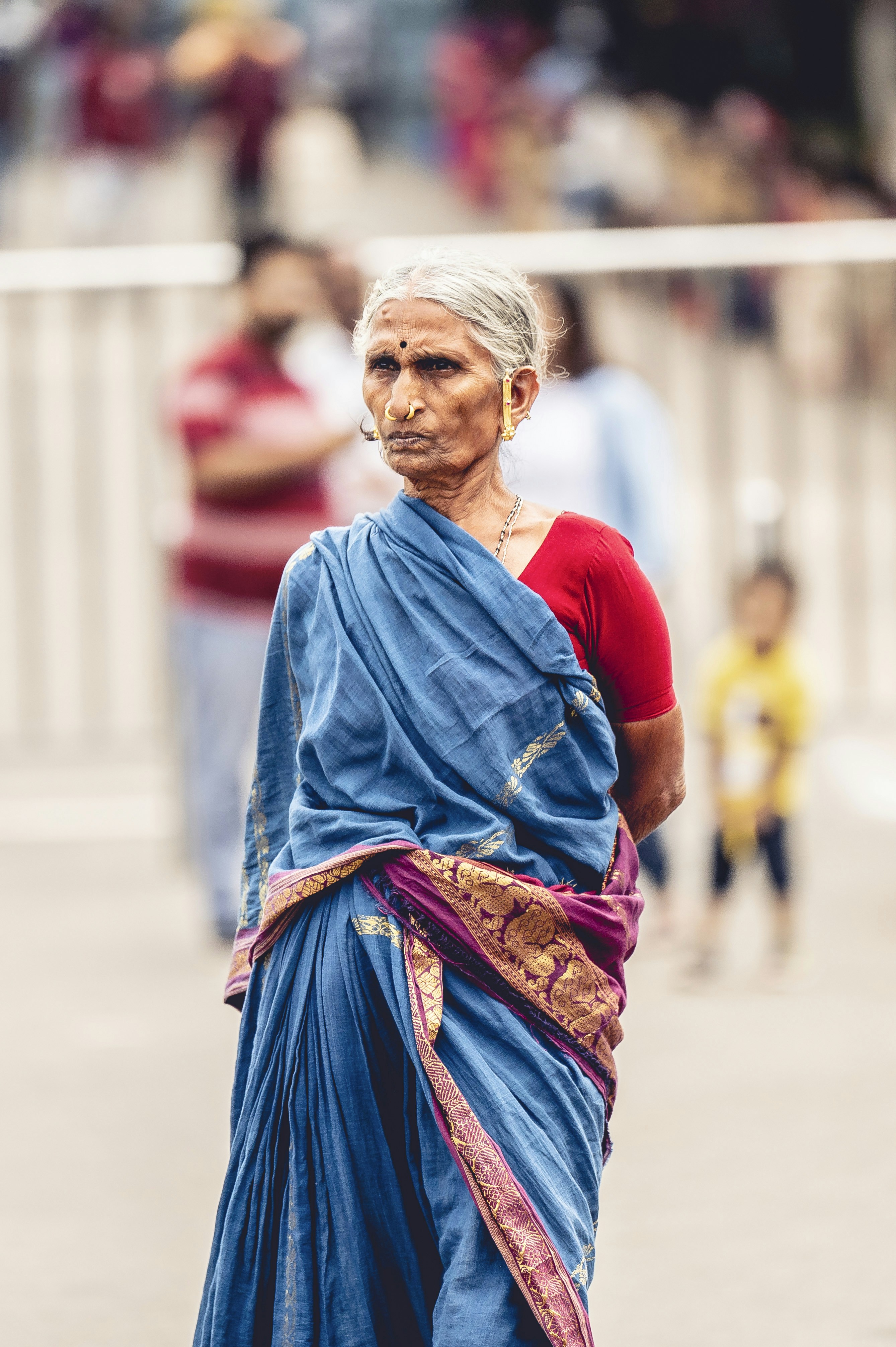 a woman in a blue sari walking down a street