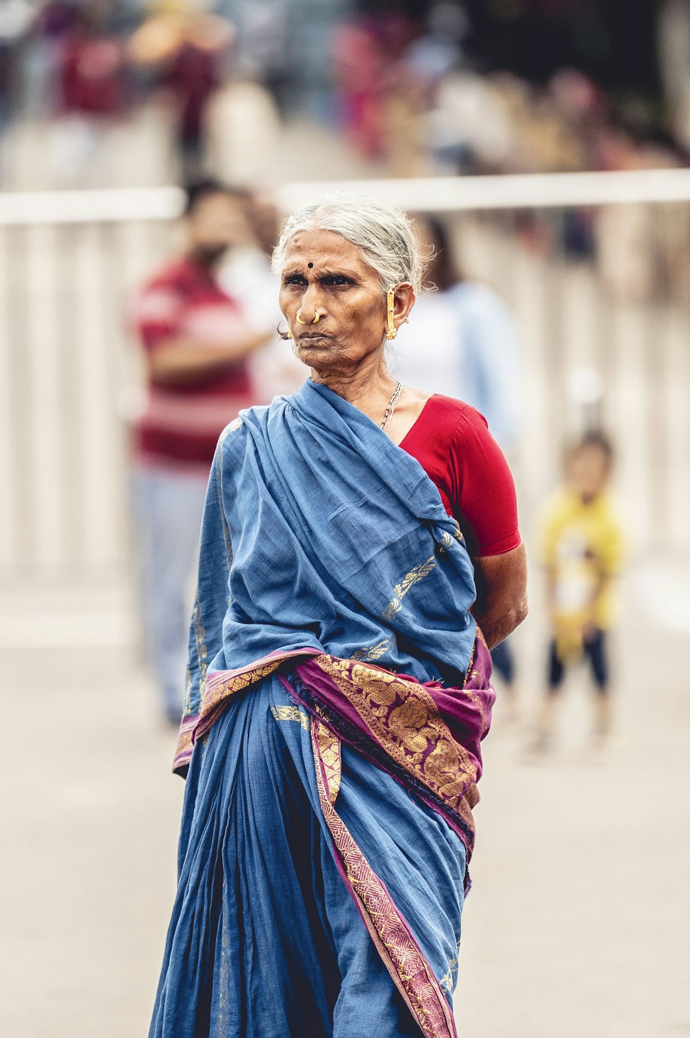 a woman in a blue sari walking down a street