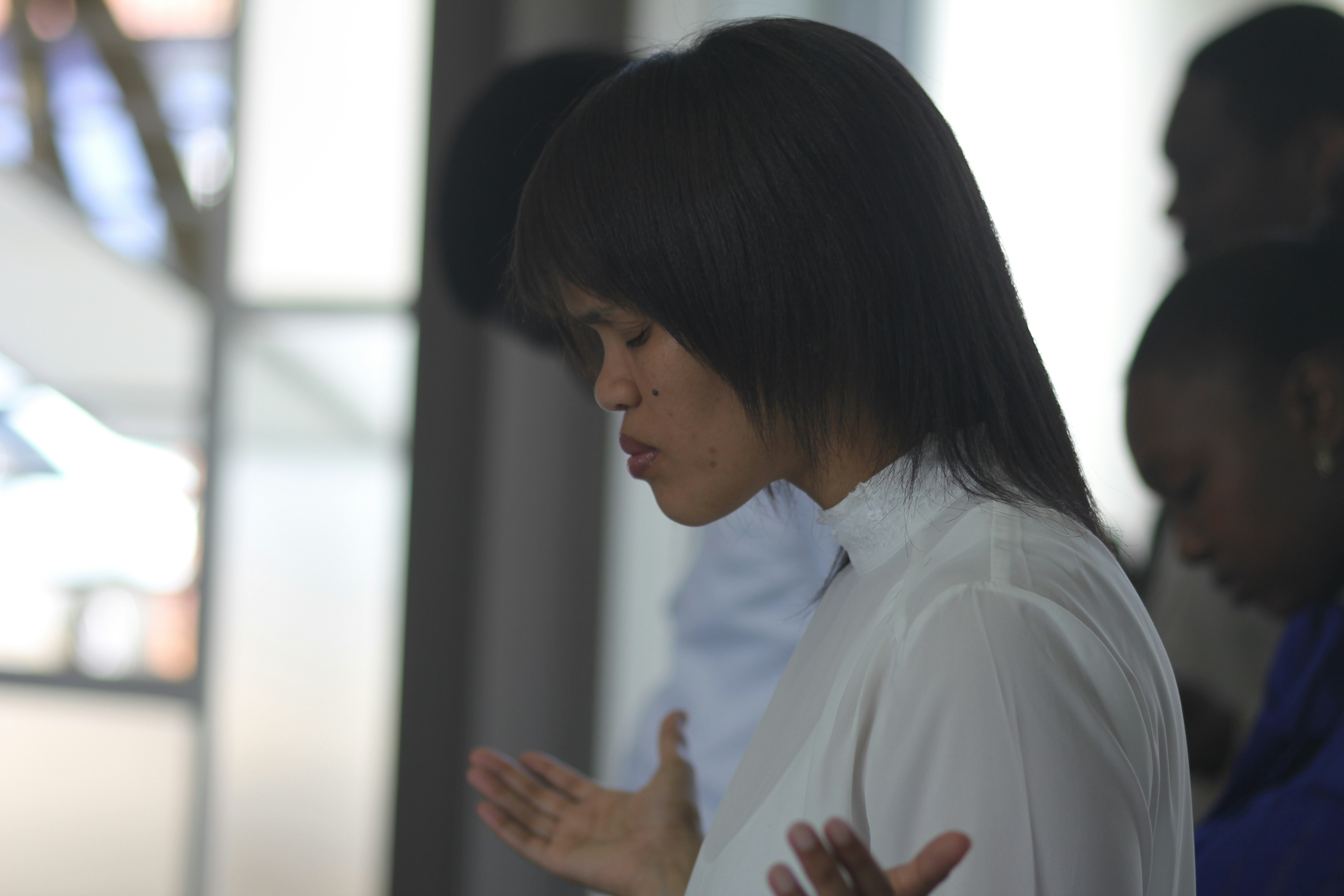 Woman with eyes closed in peaceful prayer, soft light, spiritual atmosphere