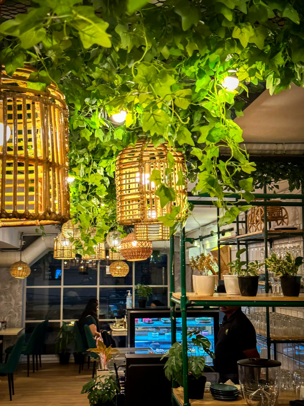 a room filled with lots of plants and hanging lights