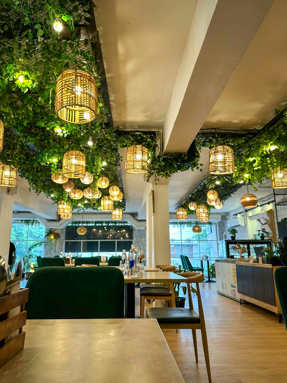 a restaurant with green chairs and hanging lights
