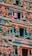 A beautifully intricate facade of a Hindu temple featuring numerous colorful sculptures depicting deities and mythical figures. The vibrant artwork is detailed with a variety of vivid colors, including teal, orange, pink, and yellow, showcasing traditional architectural elements and artistry.