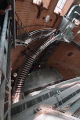 Workers fabricating a V-shaft staircase inside an industrial facility.